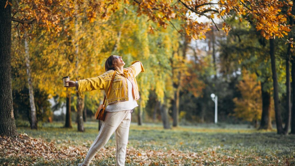 Femme heureuse et en bonne santé dans une forêt en automne.